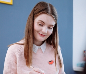 Uma mulher sorrindo anotando algumas informações